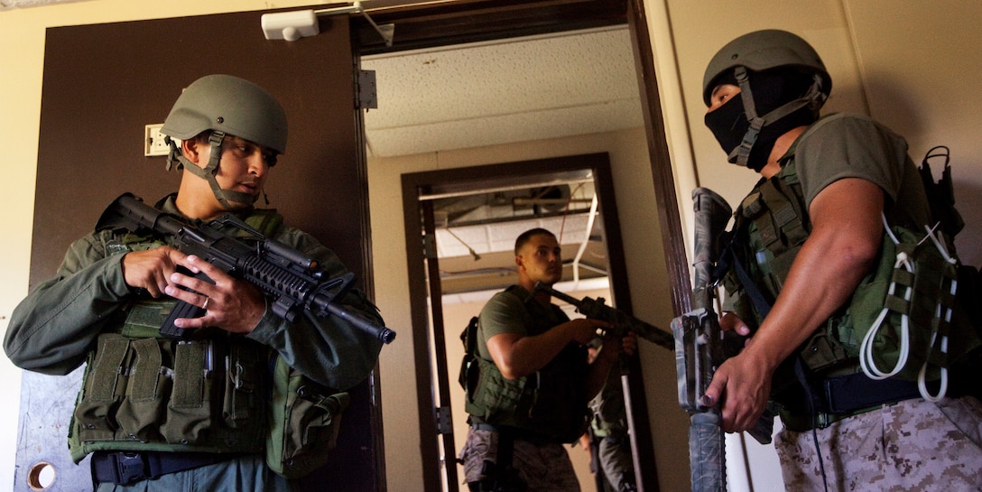 Cpl. Michael Lacson, an entry member with the Special Reaction Team, Marine Corps Base Hawaii Military Police Department, (left) waits for the command to exit the room during room clearing operations at Marine Corps Training Area Bellows, Hawaii, June 28, 2011. Lacson, a military policeman from Ewa Beach, Hawaii, is part of a squad-sized element of MPs that perform collateral duties as SRT members. Beyond their regular duties, they stand ready to respond to high-risk situations that may arise on base.