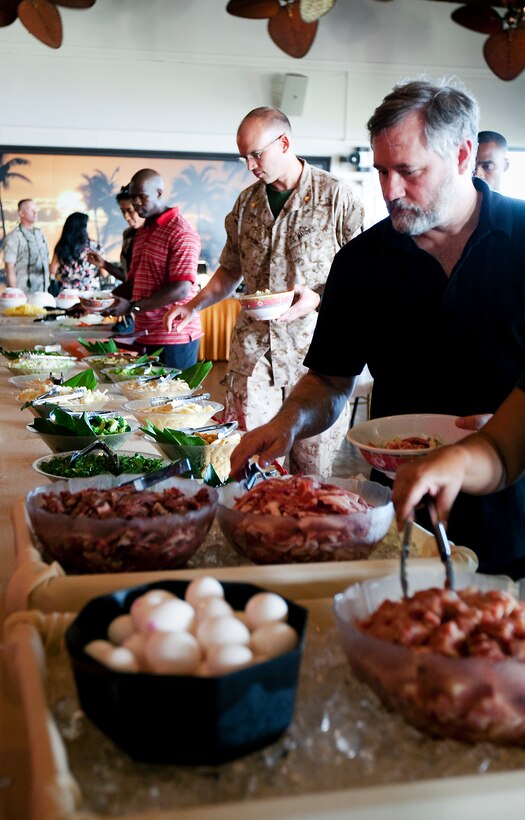 Guests at the Sunset Lanai, the all-hands club next to Bordelon Field here, serve themselves Mongolian barbecue during the grand re-opening celebration June 29. The club has the barbecue available every Wednesday evening.