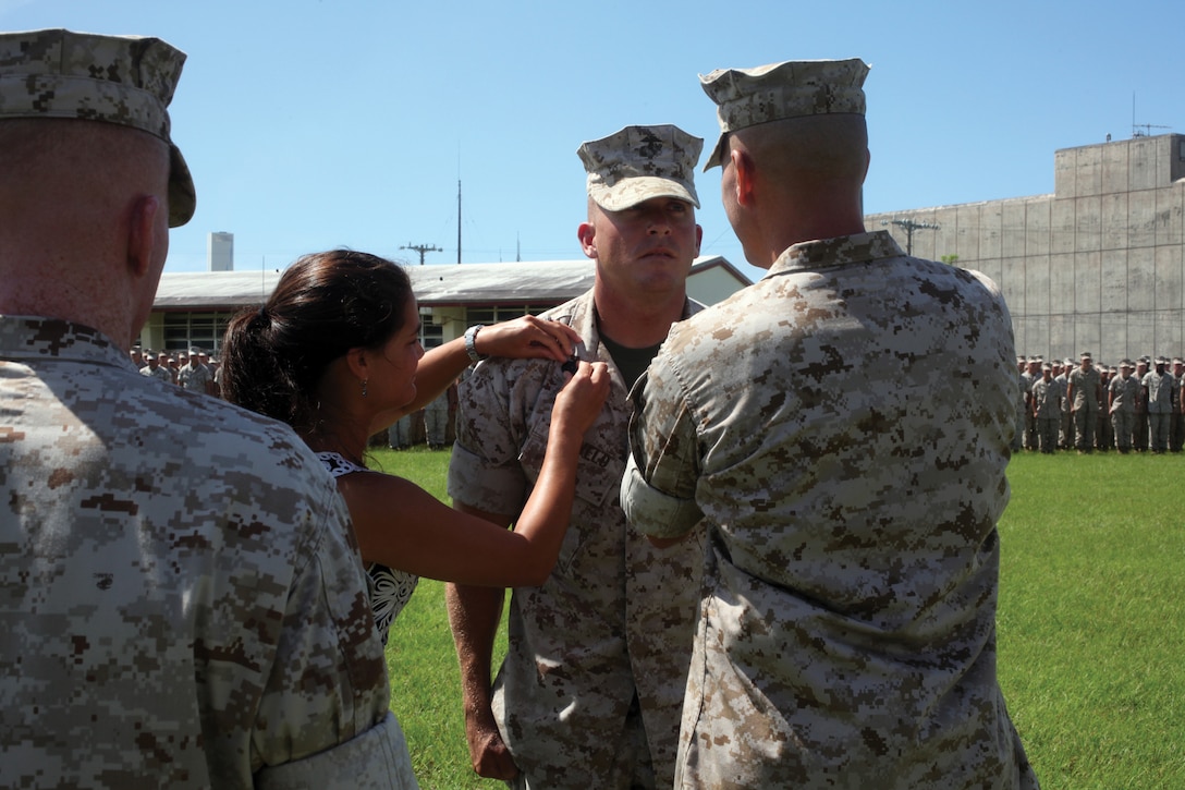 Staff Sgt. William E. Rietveld, middle, a combat engineer with 9th Engineer Support Battalion, 3rd Marine Logistics Group, III Marine Expeditionary Force, has his chevrons pinned on by his wife, Megan Rietveld, and Lt. Col. Scott A Baldwin, commander of 9th ESB.  Rietveld was combat meritoriously promoted to staff sergeant for his actions while supporting Operation Enduring Freedom.