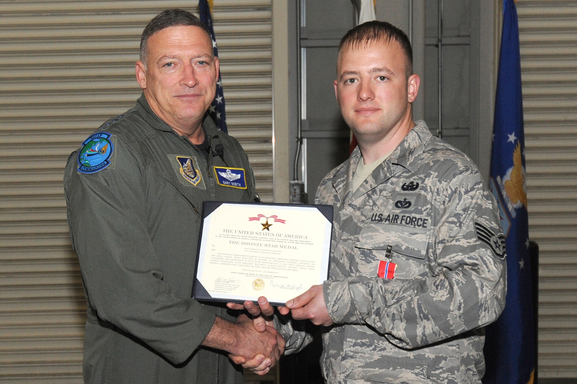MISAWA AIR BASE, Japan -- Gen. Gary North, Pacific Air Forces commander, presents Staff Sgt. Anthony Walling, 35th Civil Engineering Squadron, with a Bronze Star citation during a recent visit to Misawa Air Base June 27. Sergeant Walling earned the Bronze Star after a deployment to Afghanistan. (U.S. Air Force photo/Staff Sgt. April Quintanilla/Released)
