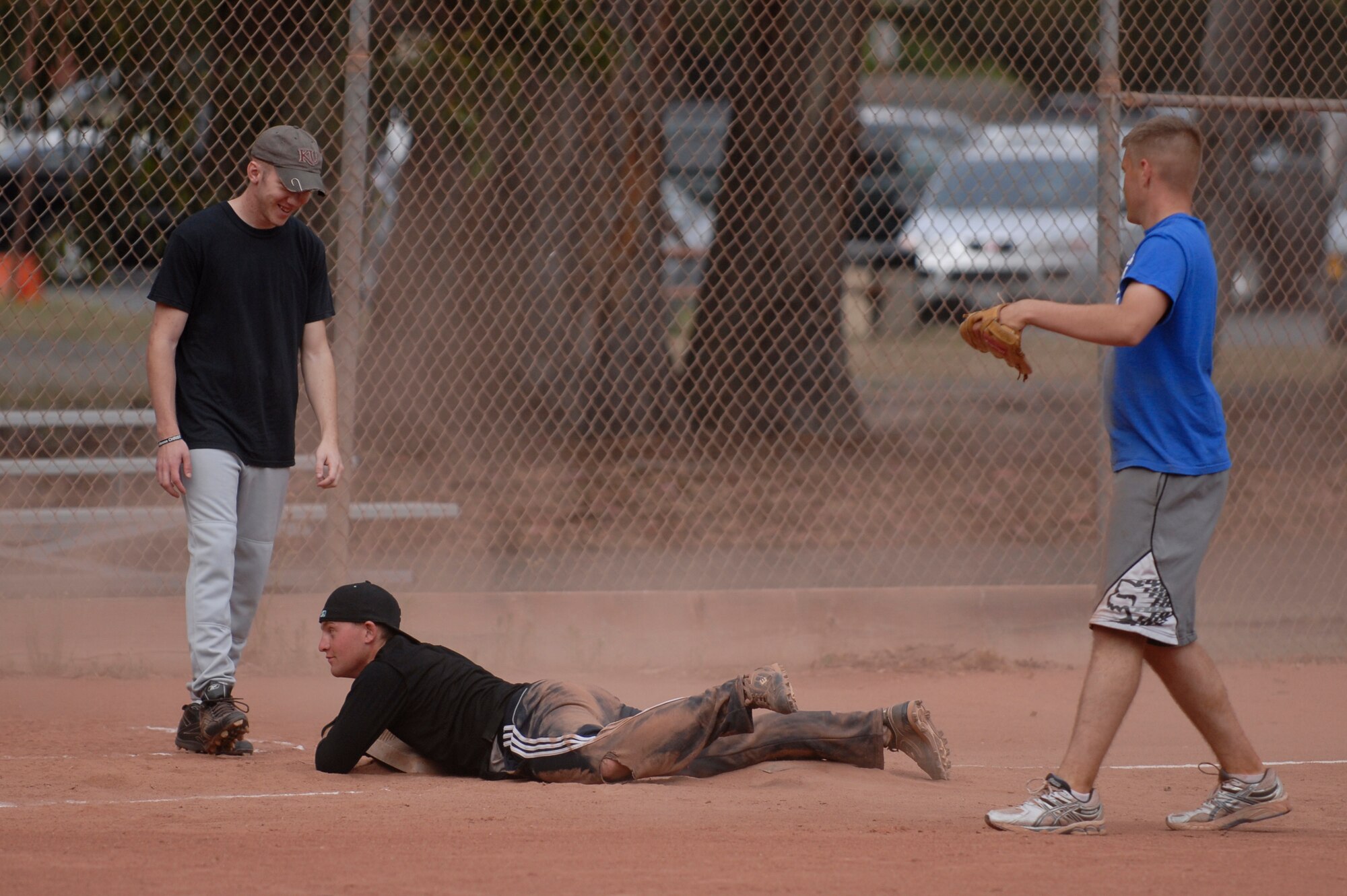 VANDENBERG AIR FORCE BASE, Calif. -- Holding third base, Shawn Acre, a 30th Security Forces Squadron team member, lays on the ground after sliding into third base during a softball game at the baseball field here Tuesday, June 28, 2011.  The 30th SFS team lost the game against the 381st Training Group team 21-9.  (U.S. Air Force photo/Staff Sgt. Andrew Satran) 