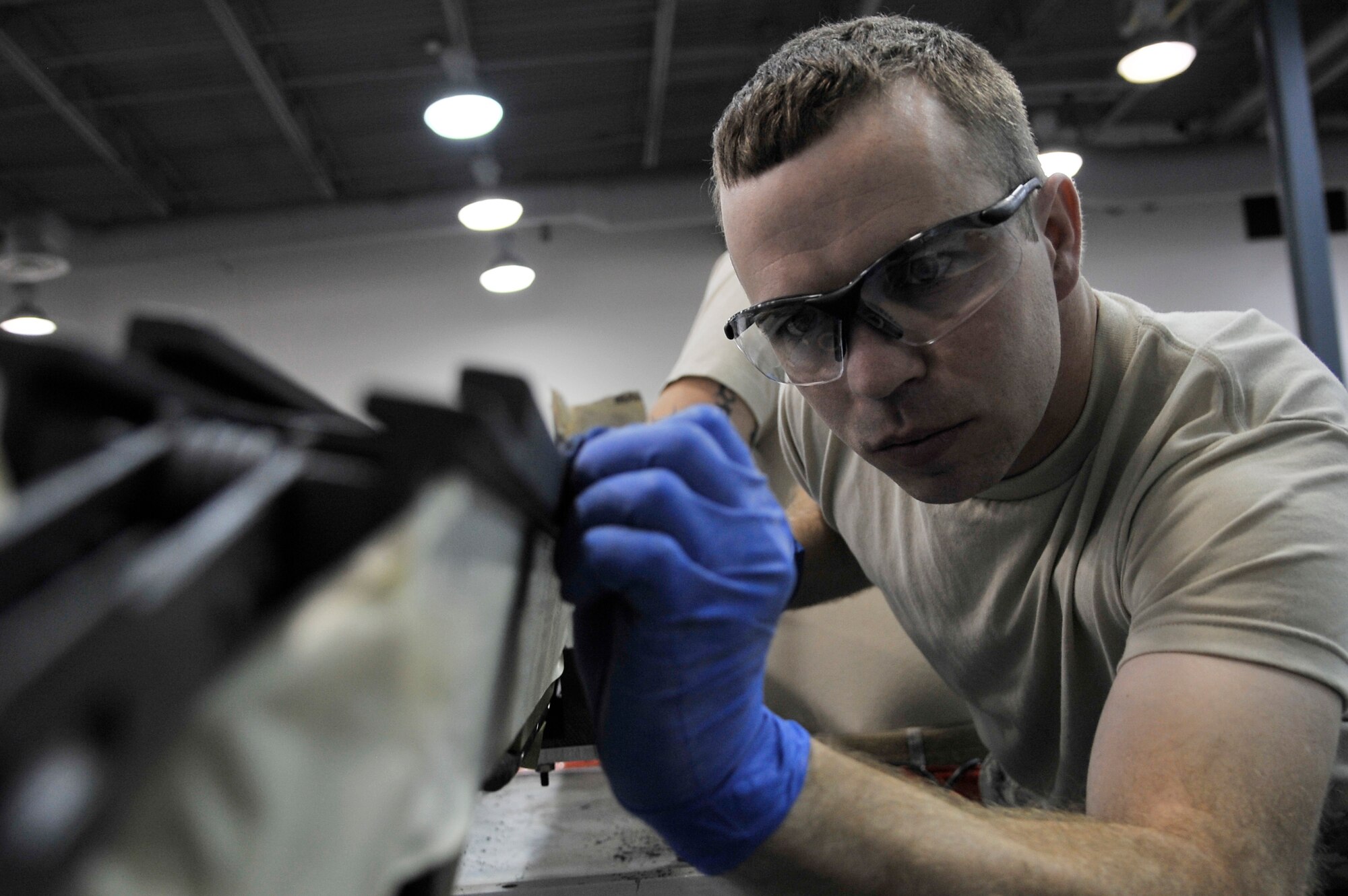 Staff Sgt. Mikel Parrish sands solid film lubricant off an S-210 launcher during an inspection June 23, 2011, Eielson Air Force Base, Alaska. The launcher is designed to hold AIM-9 missiles and Air Combat Maneuvering Instrumentation pods. Sergeant Parrish is an armament technician assigned to the 354th Maintenance Squadron. (U.S. Air Force photo/Staff Sgt. Christopher Boitz)