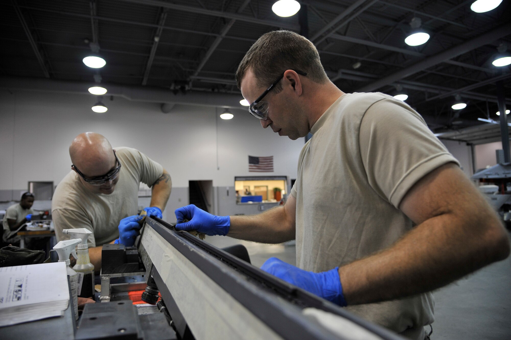 Staff Sgts. Matt Fratzke and Mikel Parrish sand solid film lubricant off an S-210 launcher during an inspection June 23, 2011, Eielson Air Force Base, Alaska. The inspection ensures the launcher functions correctly and no corrosion, cracks or damage are present. Sergeants Fratzke and Parrish are armament technicians assigned to the 354th Maintenance Squadron. (U.S. Air Force photo/Staff Sgt. Christopher Boitz)