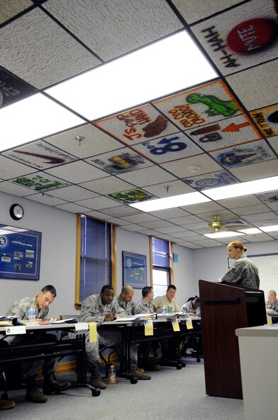Staff Sgt. Kelley Kessler, Airman Leadership School instructor, mentors her flight in enlisted performance feedback and bullet writing at Barksdale Air Force Base, La., June 22. The ceiling titles are decorated by each graduating class as a gift to their instructor to represent the heritage and legacy of past ALS flights. All Airmen in the Air Force must attend ALS prior to becoming NCOs and supervisors. (U.S. Air Force photo/Staff Sgt. John Gordinier)(RELEASED)