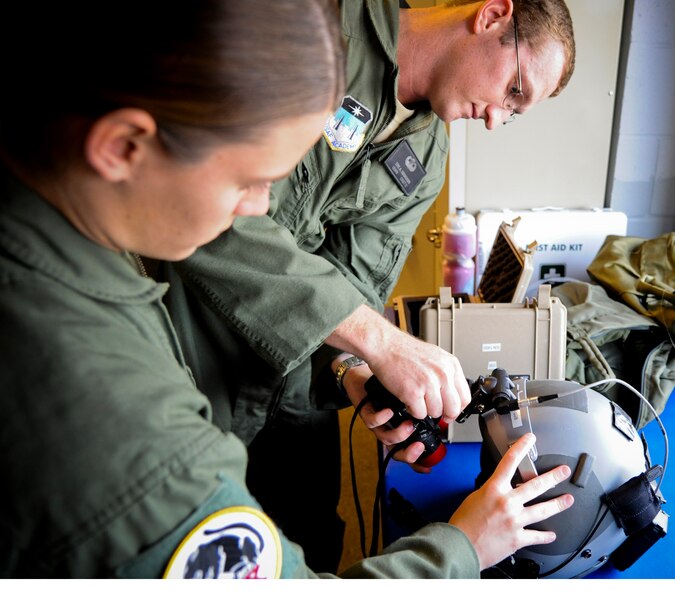 U.S. Air Force Aacademy cadets Samantha Berthiaume and Eric Dziokonski attach night vision goggles to head-gear before a flight in an HC-130P Combat King at Moody Air Force Base, Ga., June 28, 2011. Cadets Berthiaume and Dziokonski are part of a six-man team that arrived to Moody from the Academy to see what the operational Air Force is like. (U.S. Air Force photo by Airman 1st Class Paul Francis/Released)