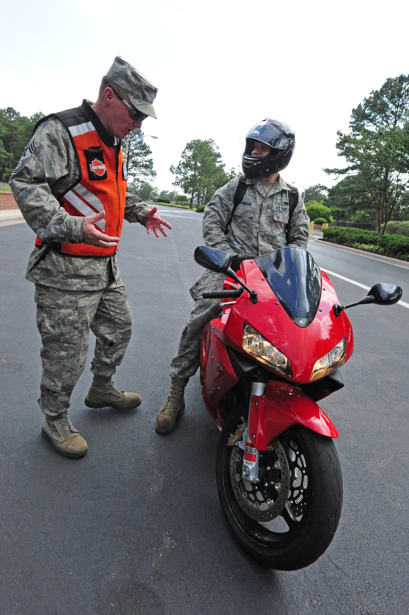 SEYMOUR JOHNSON AIR FORCE BASE, N.C. - Chief Master Sergeant Blake Malpass talks to Airman 1st Class Shane Cameron about his daily operating procedures for riding his motorcycle during a motorcycle safety check at the main gate here, June 23, 2011. The inspections were part of Motorcycle Safety Month in which riders were encouraged to practice safe operating procedures. Chief Malpass, 4th Fighter Wing command chief, is a native of Greensboro and Airman Cameron, 333rd Aircraft Maintenance Squadron technician, hails from Wasilla, Alaska. (U.S. Air Force photo/Senior Airman Rae Perry/RELEASED)