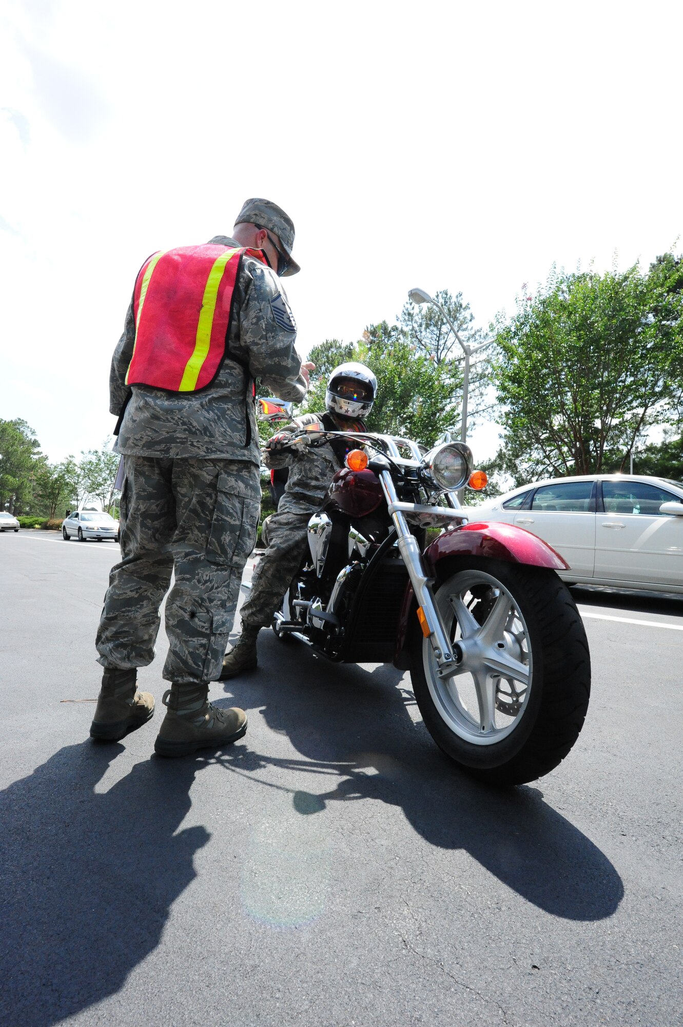 SEYMOUR JOHNSON AIR FORCE BASE, N.C. - Master Sgt. Rocky Casto talks to Tech. Sgt. Leon Lash about his inspection process before riding his motorcycle during a motorcycle safety check at the Berkeley Gate here, June 23, 2011. Base chiefs and first sergeants were at each base gate checking motorcyclists and their bikes to promote Motorcycle Safety Month. Sergeant Casto, 4th Communications Squadron first sergeant, is a native of Prescott, Ariz., and Tech. Sgt. Lash, 414th Maintenance Squadron engine specialist, hails from Durham. (U.S. Air Force photo/Senior Airman Rae Perry/RELEASED)