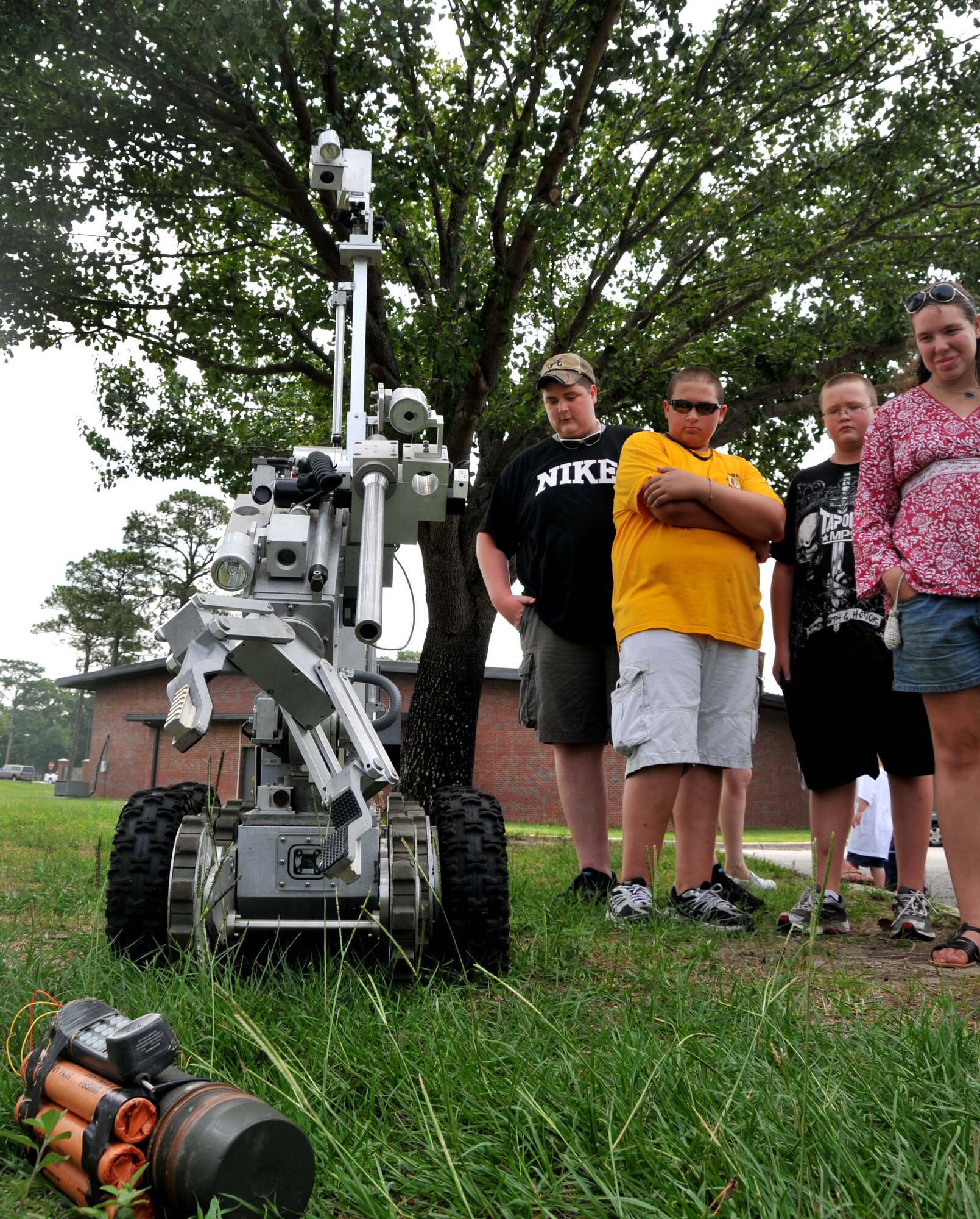 Four teenagers watch an Explosive Ordnace Disposal robot disarm a mock improvised explosive devise during an EOD demonstration June 29 on Joint Base Charleston - Air Base. A highly technical remote control dictates the movements of the EOD robot from safe distances and has two cameras, a shot gun, flashlights and a microphone. (U.S. Air Force photo /Airman 1st Class Jared Trimarchi)


