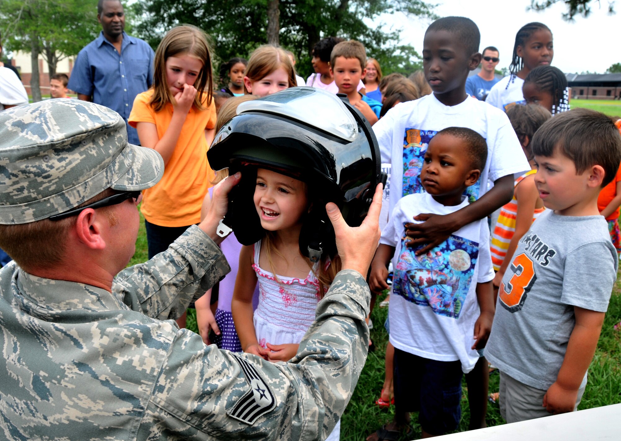 Staff Sgt. John Morrison, an Explosive Ordnace Disposal craftsman from the 628th Civil Engineer Squadron, puts a bomb suit helmet on Kaelee Strozuk during an EOD demonstration June 29 on Joint Base Charleston - Air Base. Kaelee is the daughter of Nicole Strozuk and Army Sgt. Tyson Strozuk who is station on JB CHS - Weapons Station. (U.S. Air Force photo /Airman 1st Class Jared Trimarchi)
