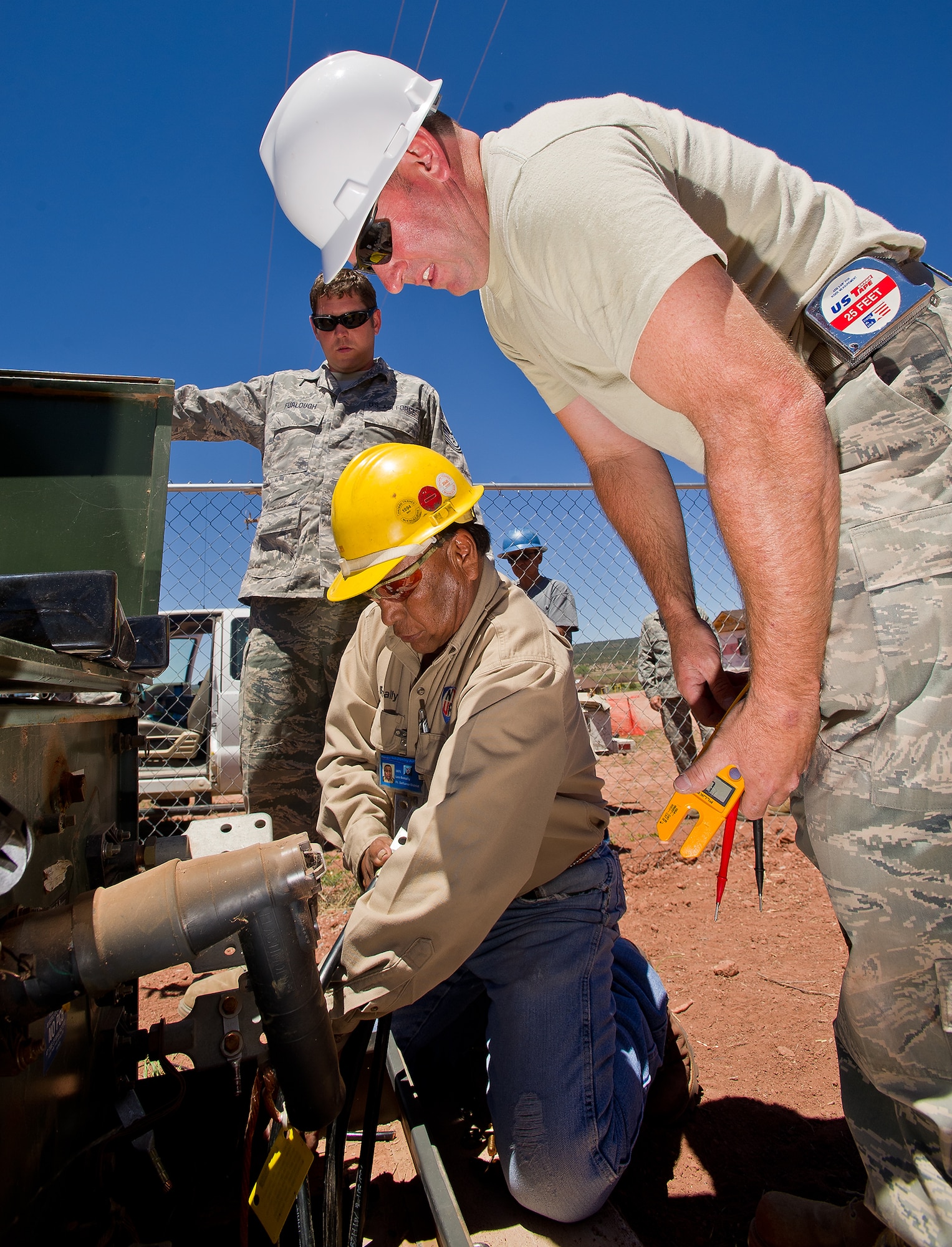 Tech. Sgts. Brian Harrison (right) and Joel Furlough, Electrical workers with the 116th Civil Engineering Squadron, troubleshoot a power outage problem with utility worker Leo Benally, Navajo Tribal Utility, at St. Michaels Association for Special Education, Window Rock, Ariz., June 7, 2011. The 116th CES deployed to the Navajo Nation reservation for two weeks as a part of the Department of Defense Innovative Readiness Training program. (U.S. Air Force photo by Master Sgt. Roger Parsons/Released)