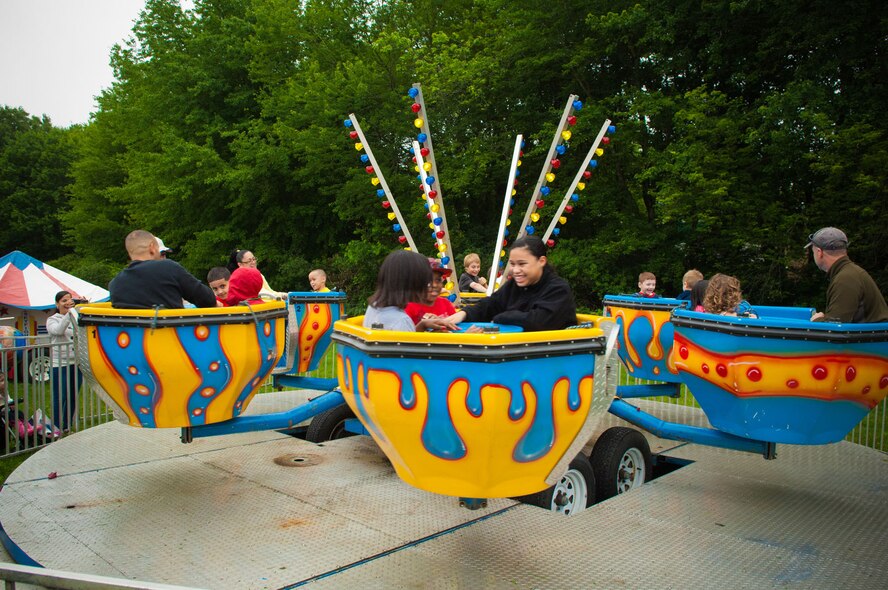HANSCOM AIR FORCE BASE, Mass. – Children and adults take a spin on one of the many carnival rides at Summer Bash in Memorial Park June 24. The Hanscom community enjoyed tubs of fun, kiddie race cars, a kiddie ferris wheel, sky fighter jets, the Aztec ride, a merry-go-round, 55-foot extreme obstacle course and inflatable boxing ring and much more during the festivities. (U.S. Air Force photo by Rick Berry)