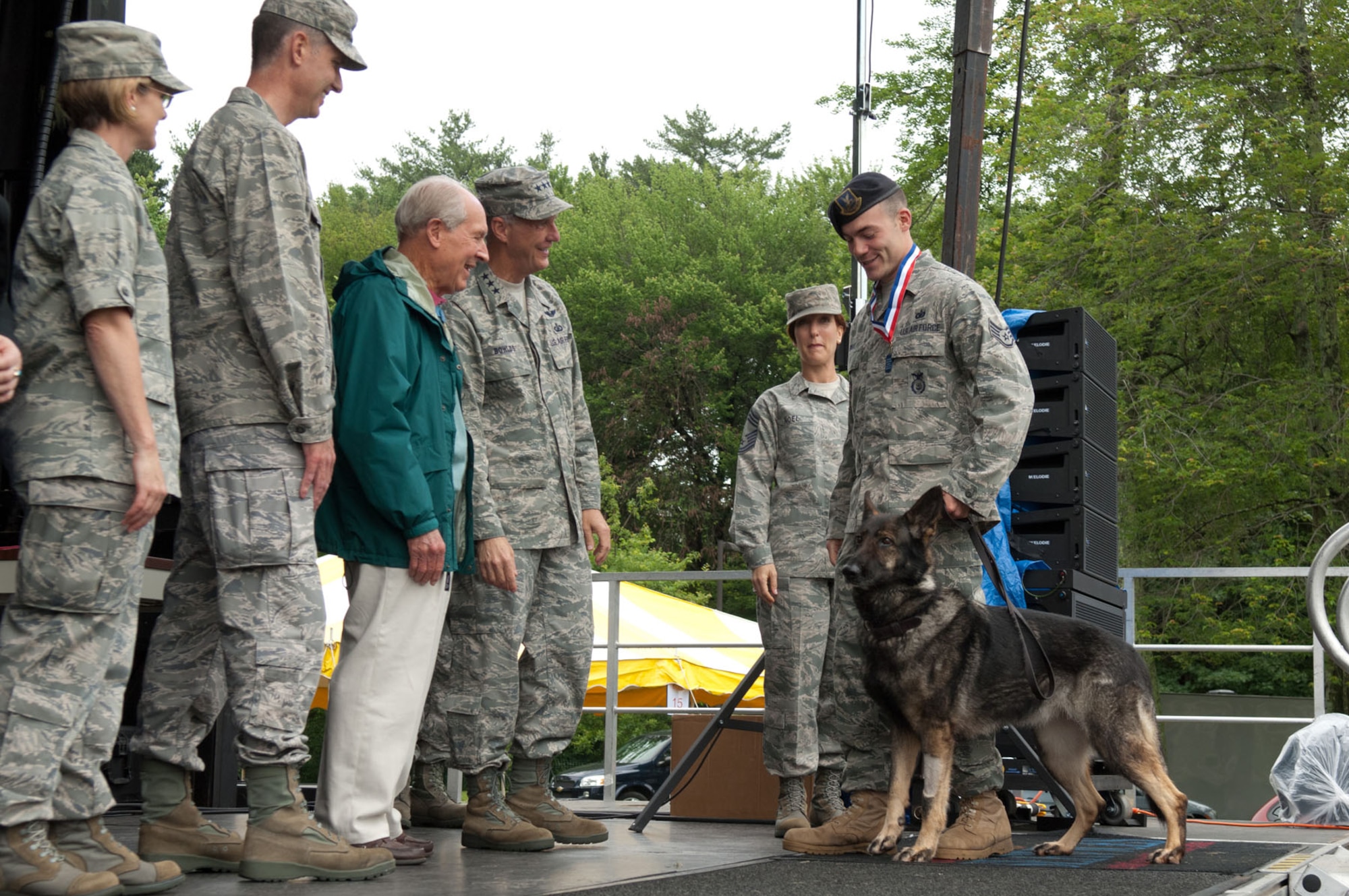 HANSCOM AIR FORCE BASE, Mass. – Staff Sgt. Joseph Wake and his Military Working Dog, Csuma, walk across the stage during Heroes Homecoming at Memorial Park June 24. Sergeant Wake and Csuma were one of two MWD teams at Hanscom that have returned home from a deployment within the last six months. (U.S. Air Force photo by Rick Berry)