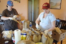 MINOT AIR FORCE BASE, N.D. -- Leah Lambert and Miriam Quarterman, both spouses here on base prepare sandwich bags June 29, to be delivered for personnel, including servicemembers, who continue working in Minot throughout the historic flood recovery. The flood situation in Minot has brought about the best in community support, with numerous volunteers from the base willing to provide assistance through any means possible. (U.S. Air Force photo/Airman 1st Class Jose L. Hernandez)