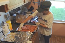 MINOT AIR FORCE BASE, N.D. -- Nastassya Sweder, wife of Capt. David Sweder 740th Missile Squadron flight commander, prepares hot dogs at her home June 29. Mrs. Sweder has spearheaded a coalition of volunteers who work to prepare meals each day for personnel, including servicemembers, who continue working in Minot throughout the historic flood recovery. (U.S. Air Force photo/Airman 1st Class Jose L. Hernandez)