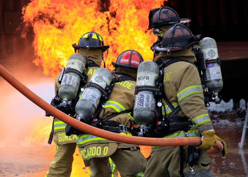 Miami-Dade Fire Rescue firefighters extinguish a  fire at the Aircraft Fire Training Facility at Homestead Air Reserve Base, June 29. The event, part of a two-week series of training, was conducted at the Aircraft Fire Training Facility here on base. The facility simulates a realistic aircraft and can be used for a number of scenarios including liquid fire, cabin fire and engine fire. By conducting the training at Homestead, M.D.F.R. saved a quarter of a million dollars, as opposed to traveling to Dallas, where they had gone in the past. (USAF photo/Mr. Ian Carrier)