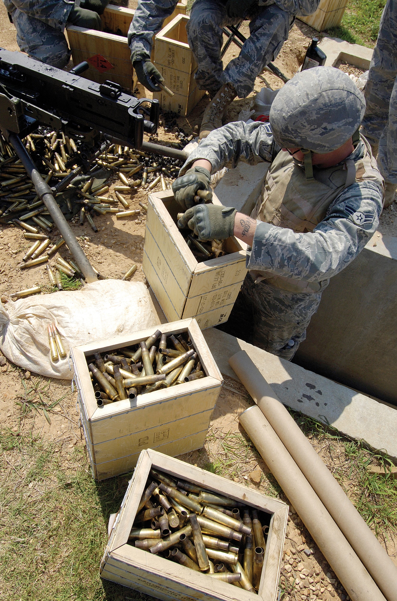 Airman 1st Class Cory Christenson loads crates with 900 empty shells from his M2 .50-caliber machine gun live-fire training June 9 at the Camp Gruber Training Center. With a firing report that is fearsome and felt and can rattle and chip teeth of the unprepared, first-time firer Airman Christenson said it was an “awesome” experience. (Air Force photos by Margo Wright)