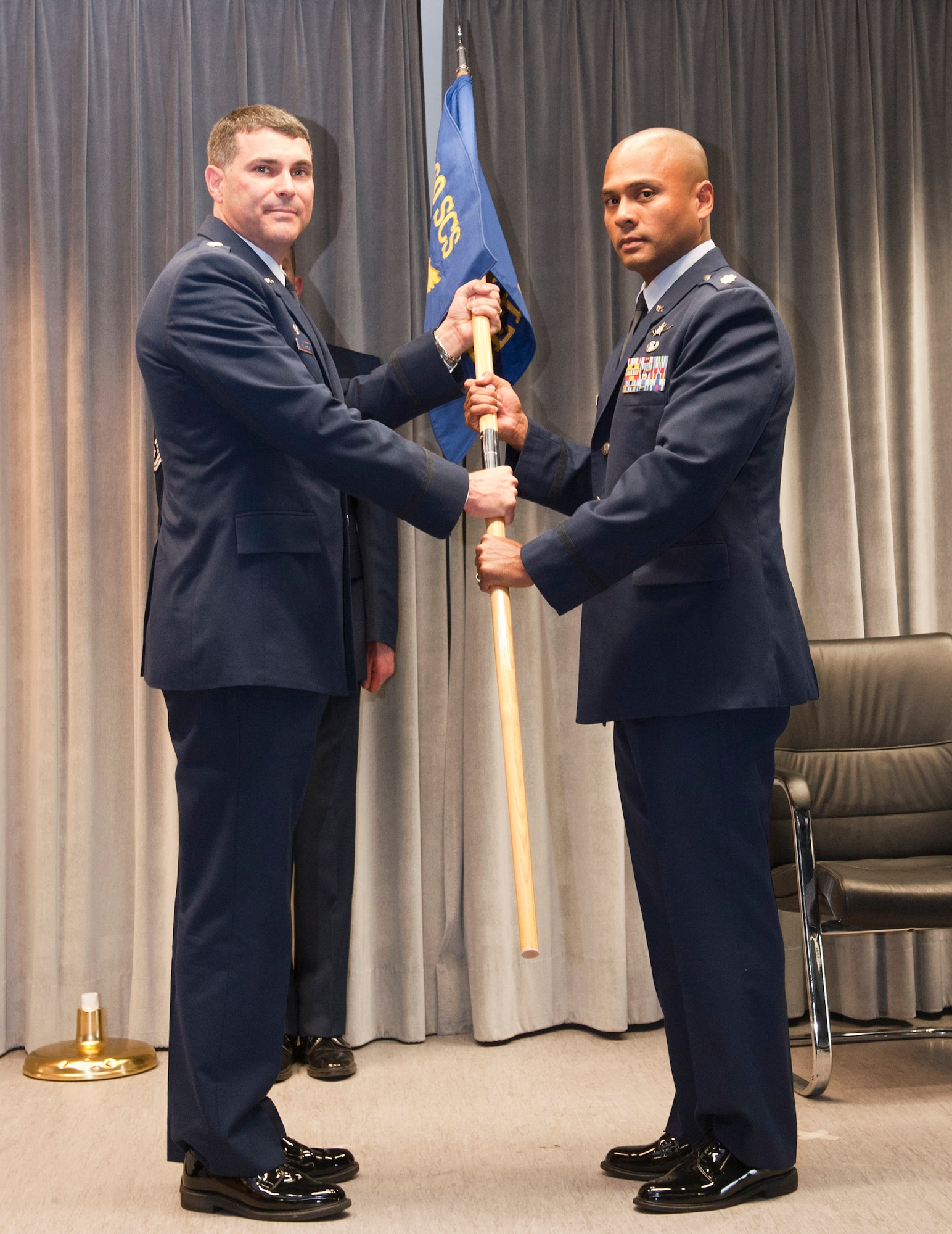 RAMSTEIN AIR BASE, Germany -- Lieutenant Col. Kelly Kanapaux, 460th Space Communications Squadron (SCS) commander, left, presents the Detachment 1, 460th SCS unit flag to incoming commander Maj. Douglas Freeman June 21, 2011. Approximately a half-dozen squadron commanders assigned to Team Buckley will change over the course of the summer months. (Courtesy Photo)