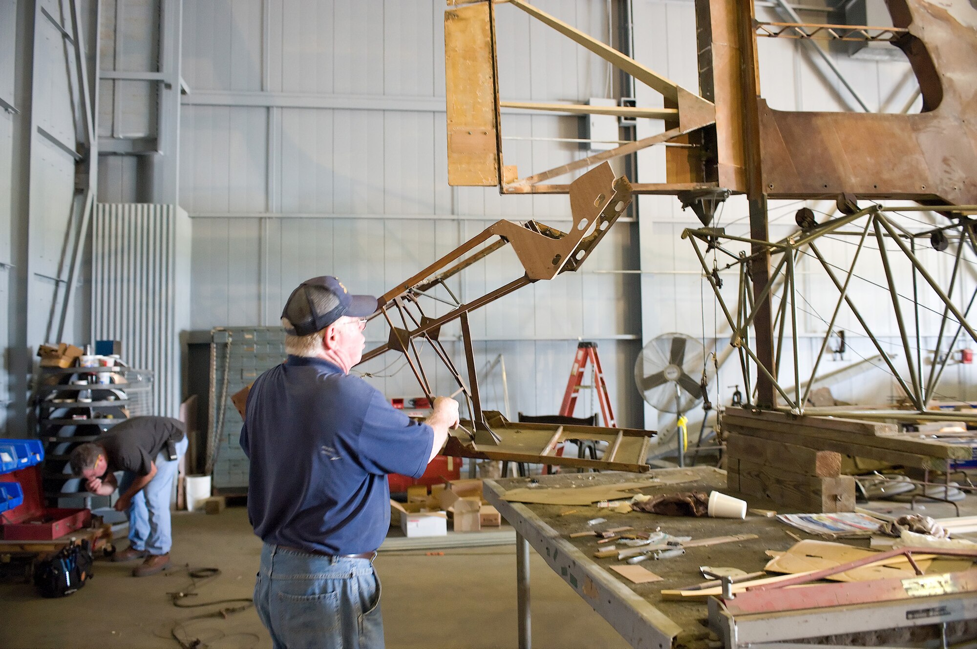 Gene Williams, a restoration volunteer, shows the tail of a Waco CG-4A Combat Glider June 23, 2011, at the Air Mobility Command Museum at Dover Air Force Base, Del. The glider is being completely restored from scrap. (U.S. Air Force photo/Steve Kotecki)