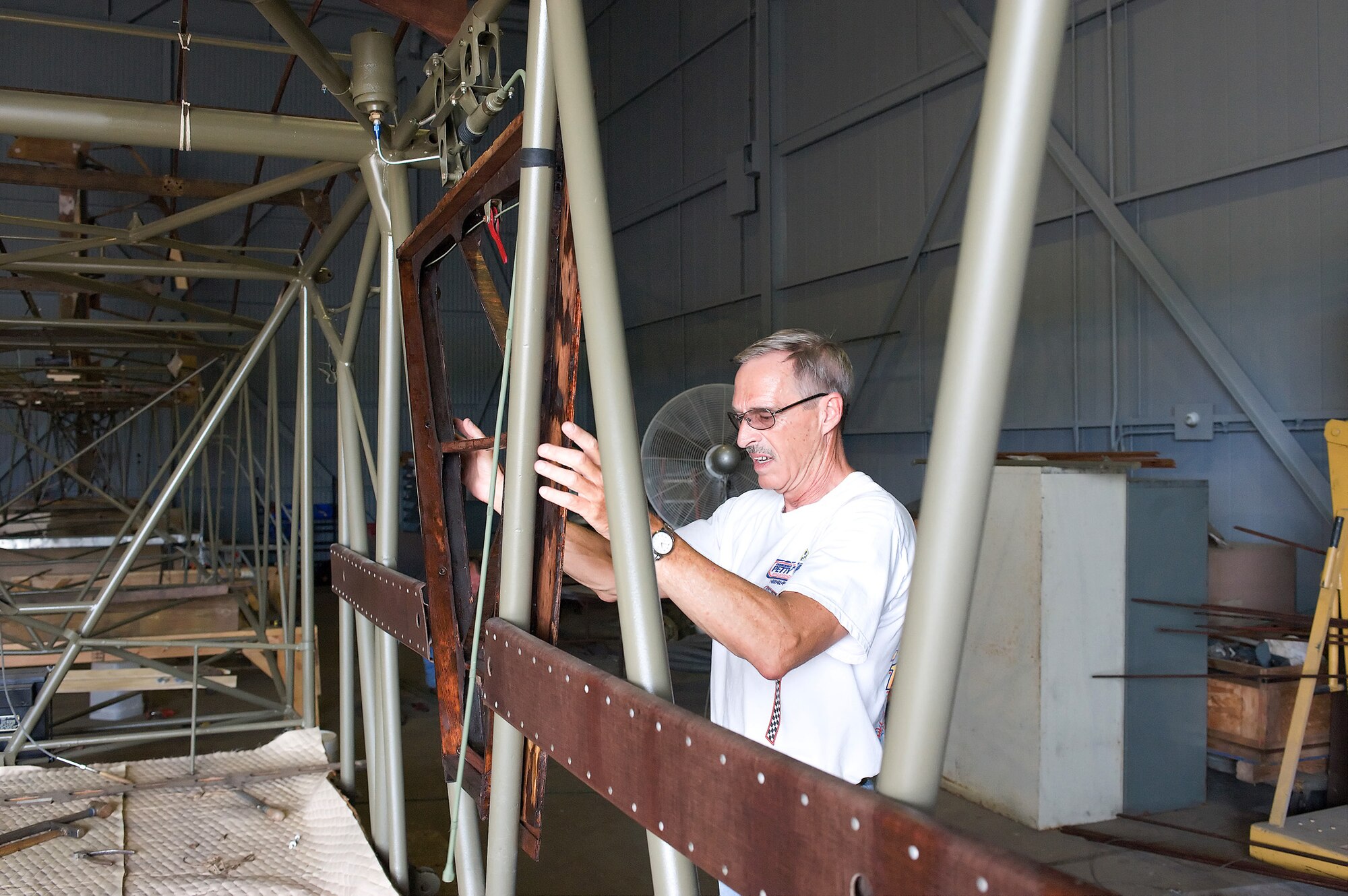 Bill Lee, a restoration volunteer, examines the frame of a Waco CG-4A Combat Glider June 23, 2011, at the Air Mobility Command Museum at Dover Air Force Base, Del. The glider is being completely restored from scrap. (U.S. Air Force photo/Steve Kotecki)