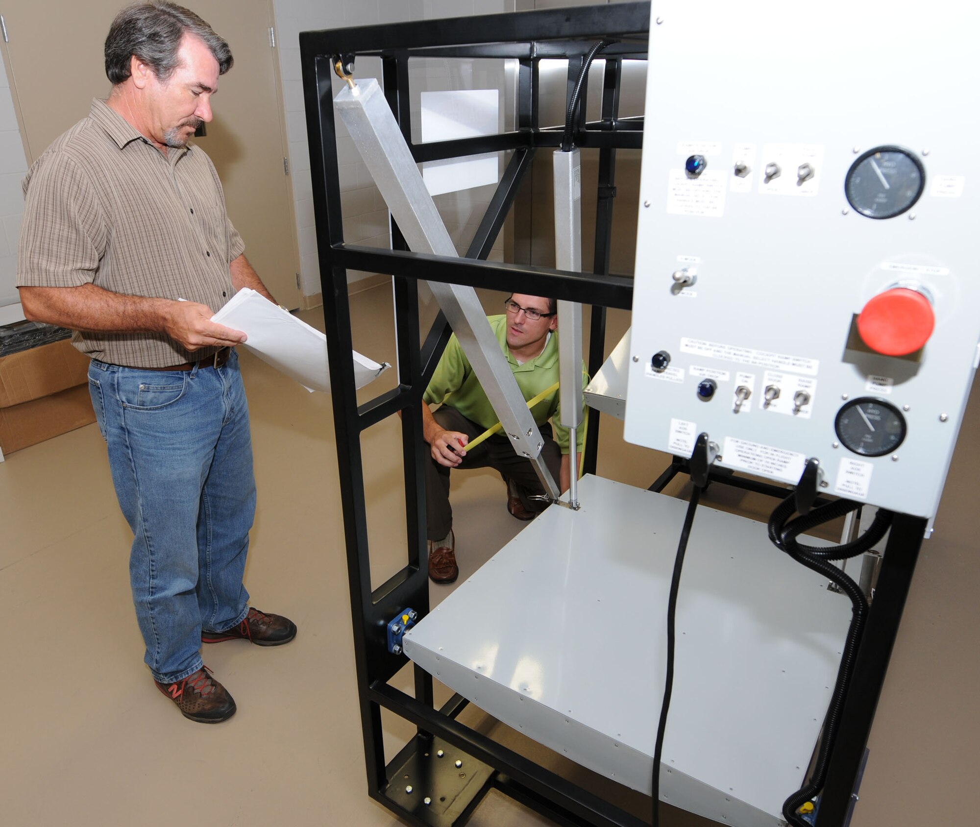 Ronald Holtorf, left, 81st TRSS, and Mr. Lassabe perform a quality assurance inspection to ensure the travel distance of the doors on the trainer meet specifications prior to shipping to Sheppard.  (U.S. Air Force photo by Kemberly Groue)