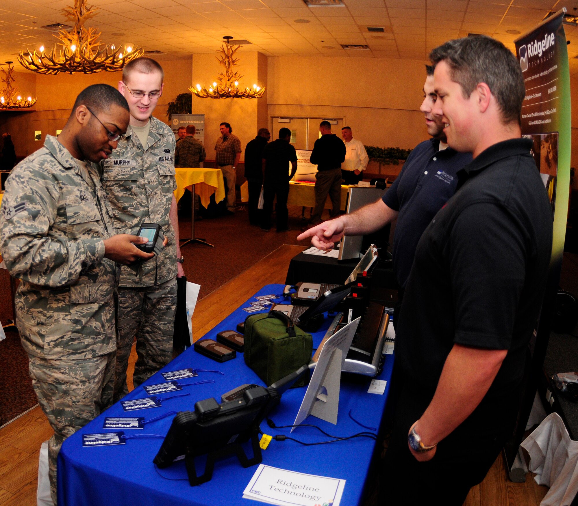 Airman 1st Class Marcus Hall and Staff Sgt. Shane Murphy try out a mobile device June 23, 2011, Eielson Air Force Base, Alaska.  Technology Demo Day made it possible for numerous people to view new audio and visual enhancements.  Airman Hall and Sergeant Murphy are network administrators assigned to the 354th Communication Squadron.  (U.S. Air Force photo by Airman 1st Class Yash Rojas)
