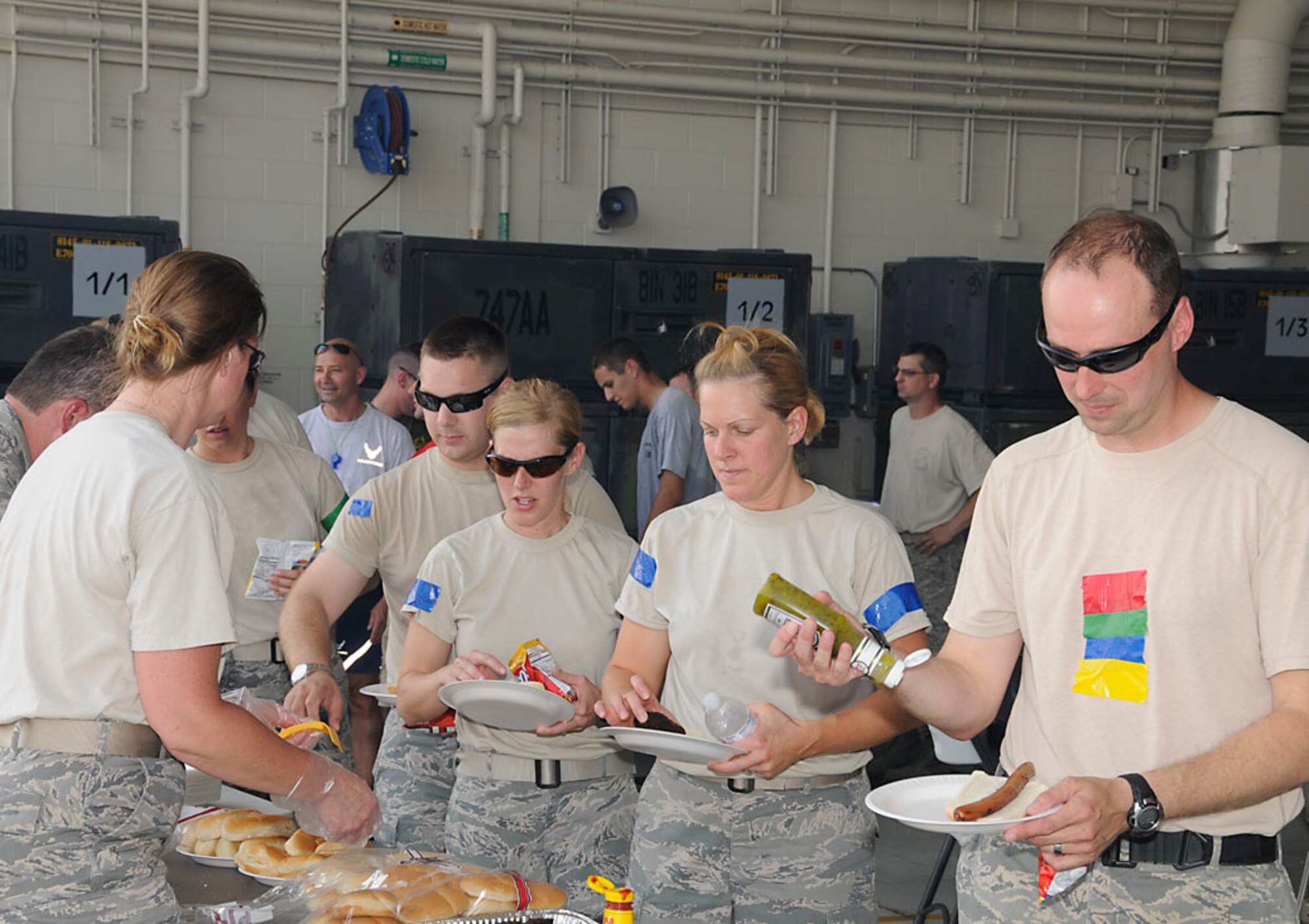 Security Forces Squadron participants, Staff Sgt. Brandon Criss, Tech. Sgt. Amber VanNess, Tech. Sgt. Jamie Renehan, and Staff Sgt. Rick Tryon (who appears to be neutral) flow through the chow line after working up an appetite on the battle field. Photo by Master Sgt. John M.  Day/Released