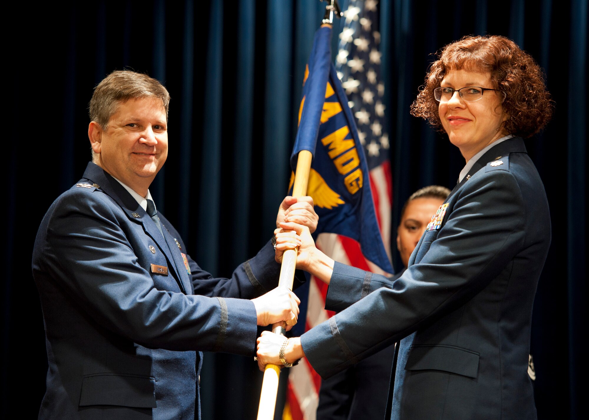 YOKOTA AIR BASE, Japan -- Col. (Dr.) Lee Harvis, 374th Medical Group commander, passes the 374th Medical Surgical Squadron guideon to Lt. Col. Jill O'Rear, 374th MSGS commander, signifying the start of her command here June 23, 2011. (U.S. Air Force photo/Staff Sgt. Samuel Morse)