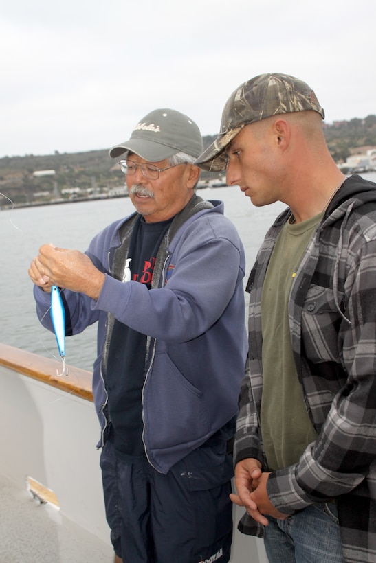 Larry Yoshida, charter master, teaches Sgt Mario Tabarracci, drill instructor, Company G, how to tie the San Diego jam knot aboard The Indian.