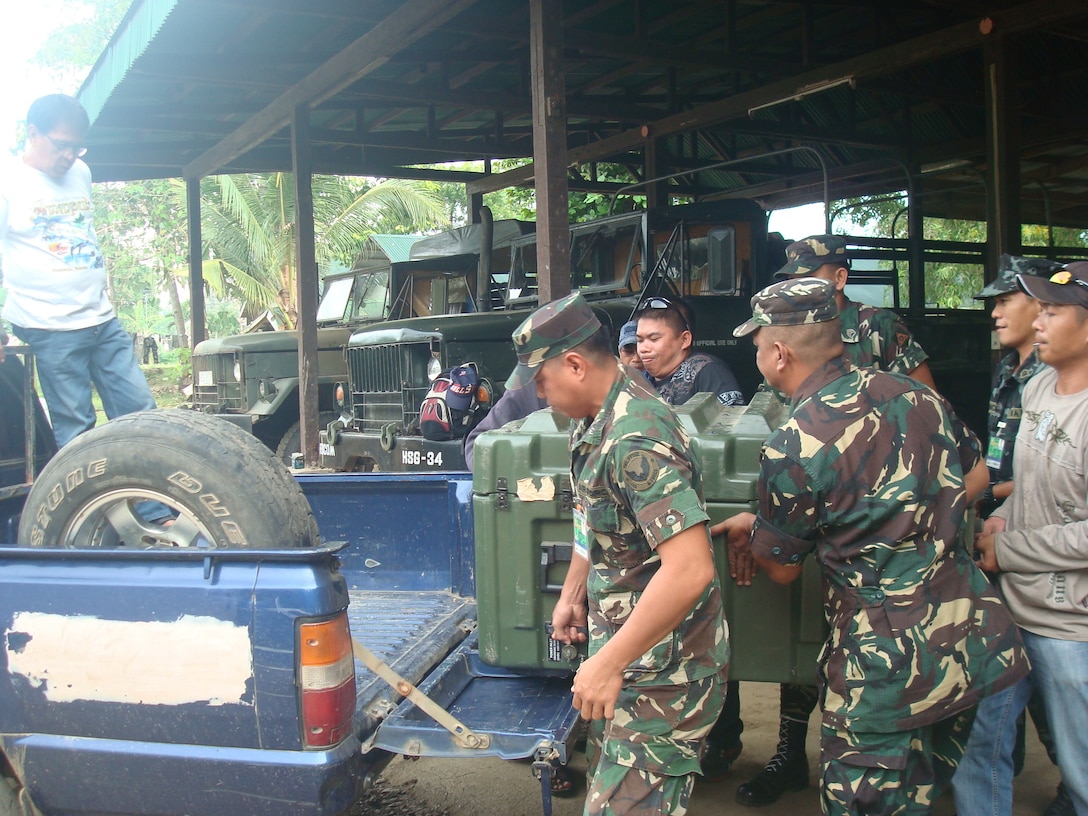 Service members from the Armed Forces of the Philippines’ National Development Support Command load equipment onto a truck, which is later transported to Palaw-an, an island southeast of Manila, Philippines. AFP deployed a five-man team with NADESCOM to Palaw-an, June 23, for a humanitarian operation to provide aid and prevent the spread of a cholera outbreak.