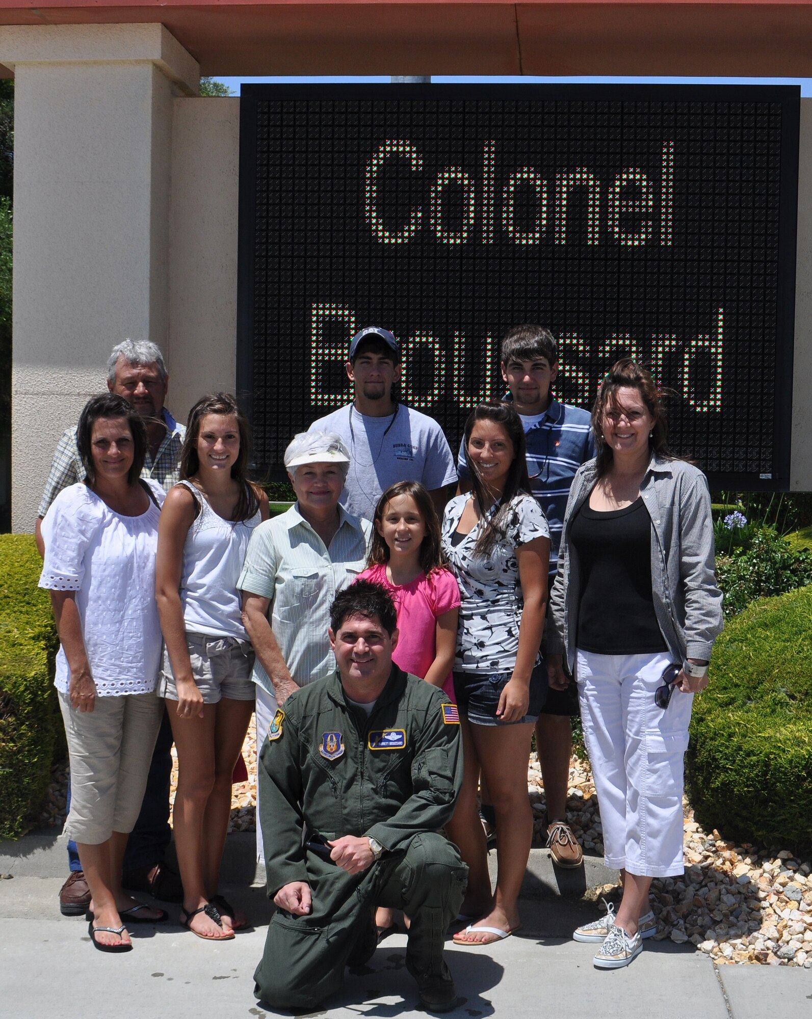 TRAVIS AIR FORCE BASE, Calif. -- Col. Barrett Broussard poses in front of the flight line marquee with his family while he dries out after his "fini" flight June 24. The colonel enjoyed his last Air Force flight in a Travis C-17, "The Spirit of Rio Vista." He was met, and hosed down, by his family, friends and Airmen of Team Travis. His new "punk" hair style courtesy of his nieces. (U.S. Air Force photo/Senior Master Sgt. Ellen L. Hatfield)