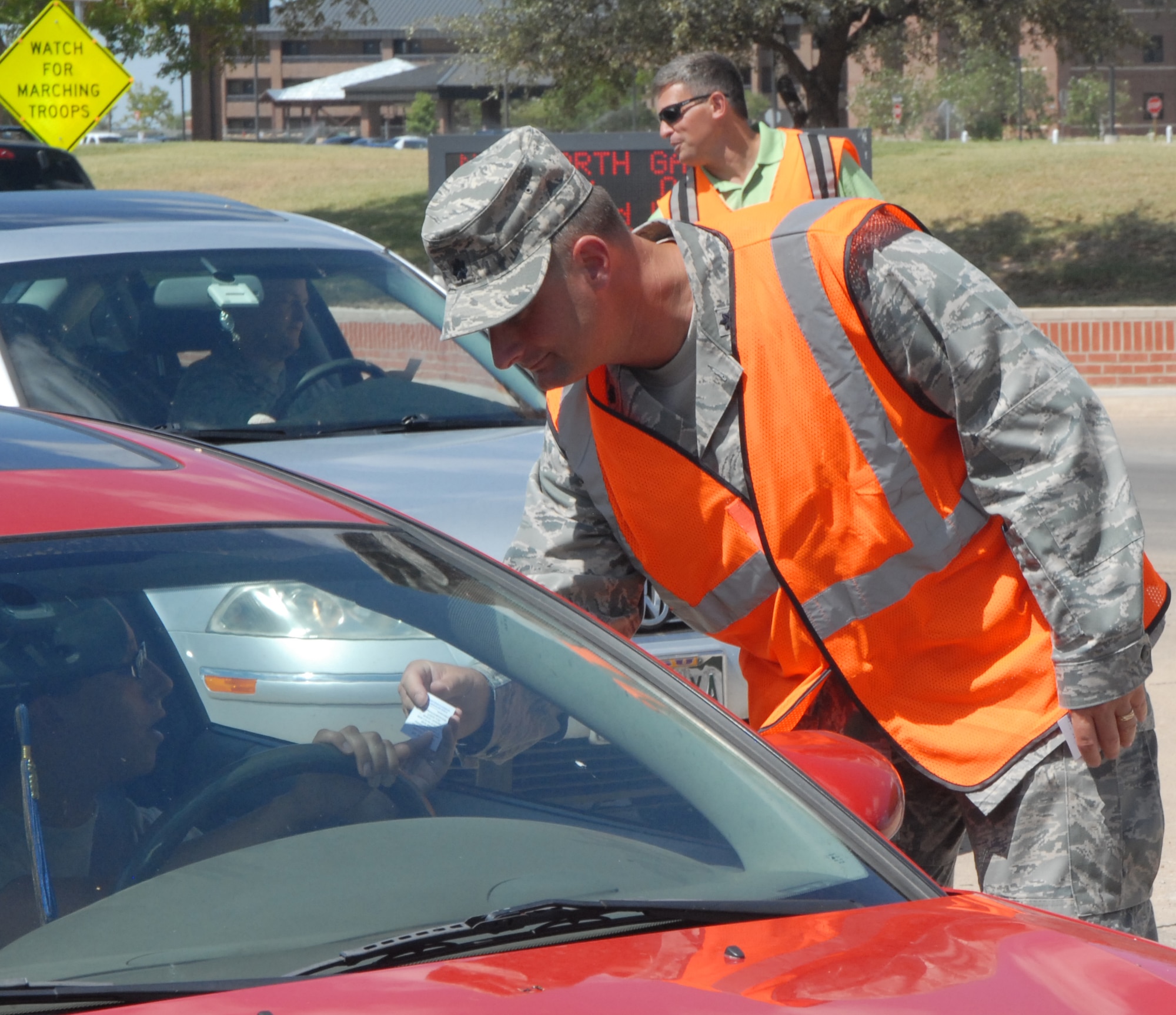 GOODFELLOW AIR FORCE BASE, Texas -- Lt. Col. Tyler Sanders, 17th Medical Support Squadron Commander, joined other base leaders June 30 at the North and South gates to hand out Safety cards to Team Goodfellow members departing for the long holiday weekend.  (U.S. Air Force photo/Connie Hempel)