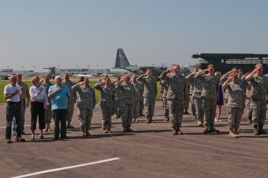 State workers and Airmen of the 133rd Airlift Wing render appropriate honors during the national anthem as the Wing dedicated a new de-icing pad on the ramp of the Minnesota Air National Guard Base on June 30, 2011 at the Minneapolis, St. Paul international airport. After speeches by Col. Greg Haase, Wing commander, Barbara O’Brien, the 133rd AW Senior Engineering Specialist Architect, Maj. Georg Fischer, environmental manager and Minnesota’s Fifth District Congressman Keith Ellison, the ribbon was enthusiastically cut. USAF official photo by Senior Master Sgt. Mark Moss