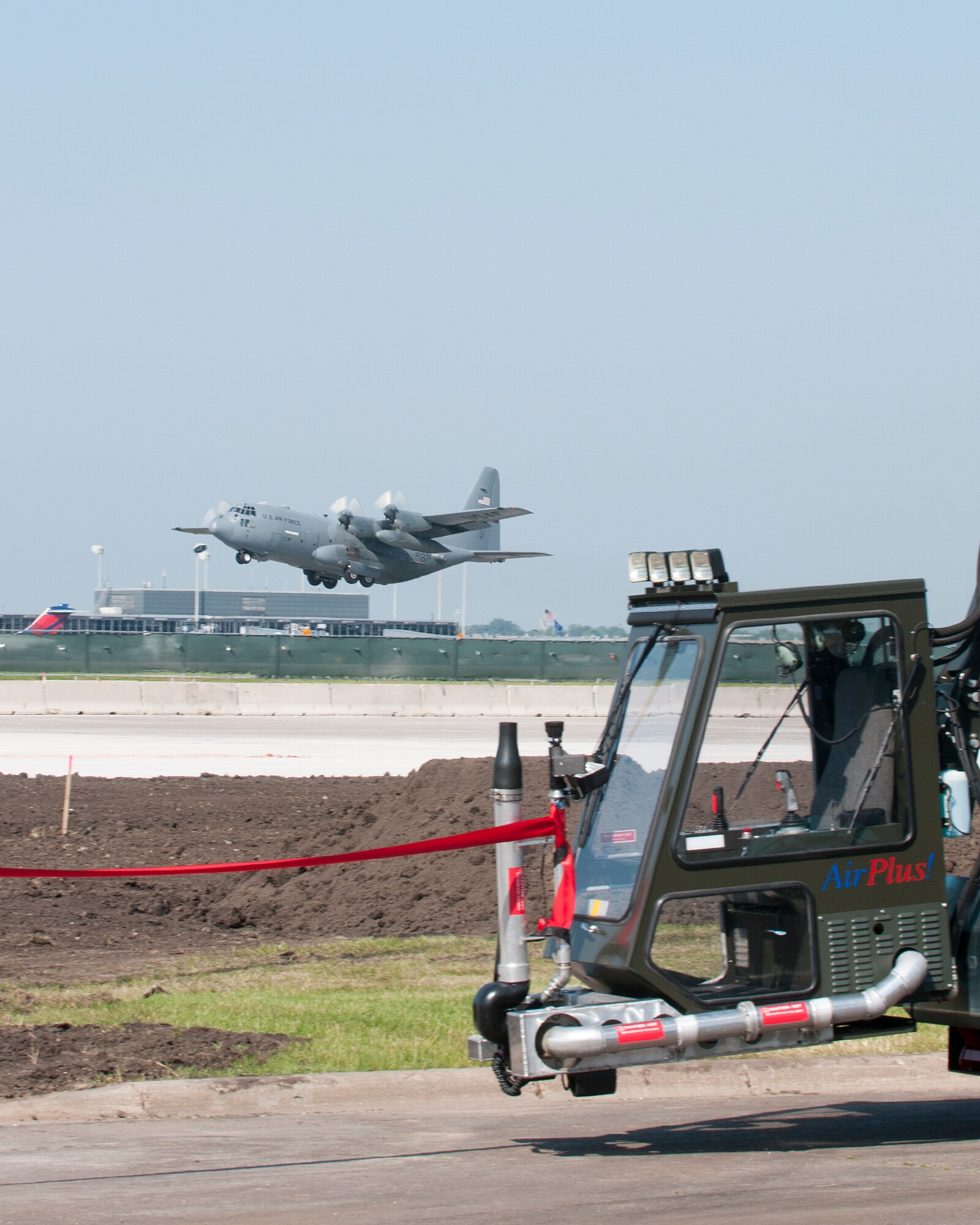 A C-130 launches behind the flightline as the 133rd Airlift Wing dedicated a new de-icing pad on the ramp of the Minnesota Air National Guard Base on June 30, 2011 at the Minneapolis, St. Paul international airport. After speeches by Col. Greg Haase, Wing commander, Barbara O’Brien, the 133rd AW Senior Engineering Specialist Architect, Maj. Georg Fischer, environmental manager and Minnesota’s Fifth District Congressman Keith Ellison, the ribbon was enthusiastically cut. USAF official photo by Senior Master Sgt. Mark Moss