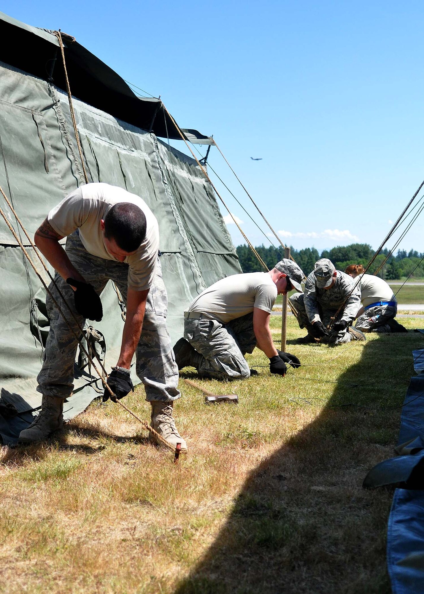 Airmen assigned to the 627th Civil Engineering Squadron, 62nd Maintenance Squadron and 446th Airlift Wing set up tents at Heritage Hill June 21 at Joint Base Lewis-McChord, Wash. (U.S. Air Force photo/Airman 1st Class Leah Young)