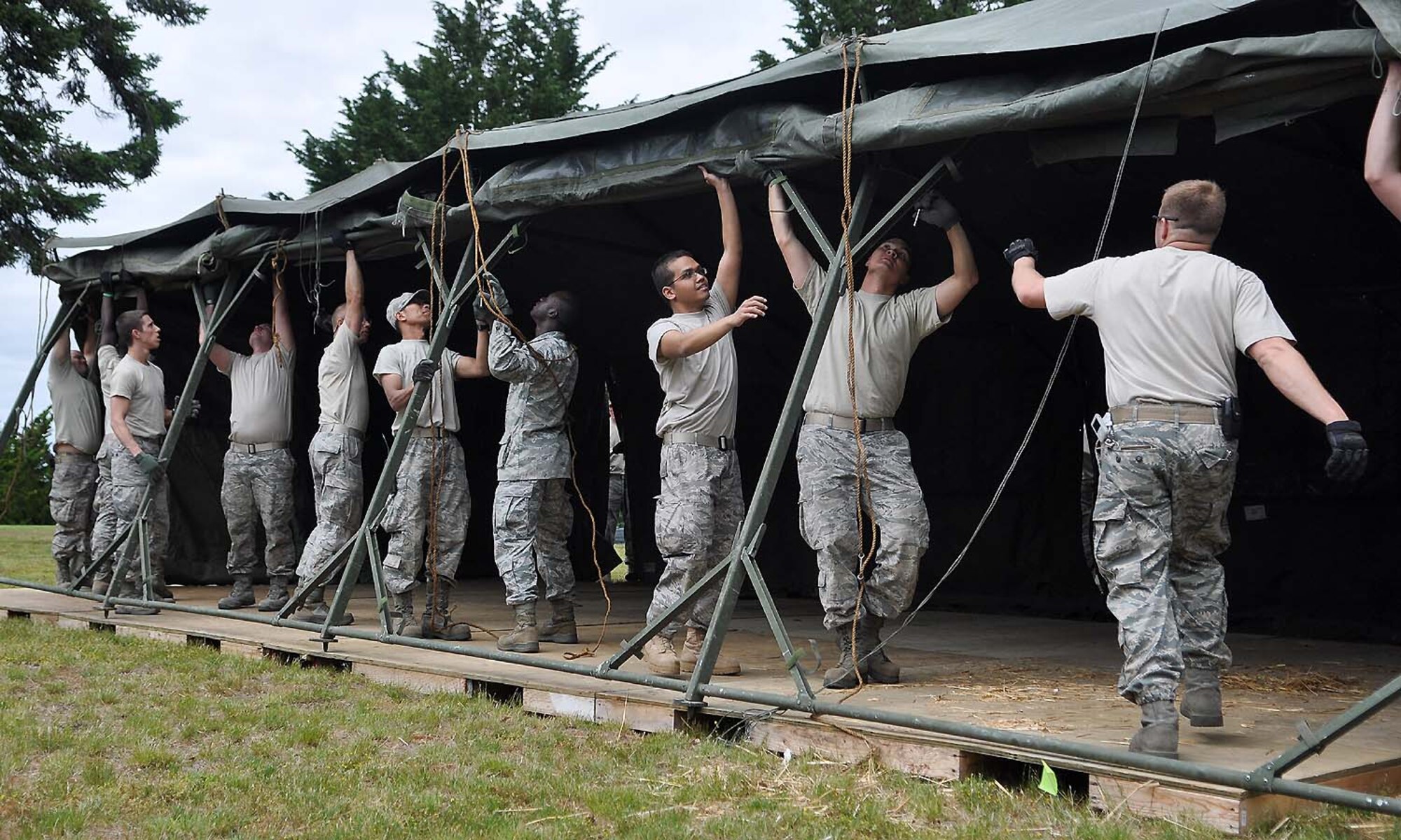 Airmen assigned to the 627th Civil Engineering Squadron, 62nd Maintenance Squadron and 446th Airlift Wing set up tents at Heritage Hill June 21 at Joint Base Lewis-McChord, Wash. “Every single Airman from the civil engineering squadron is out here with gloves on, helping us prepare for Rodeo,” said Master Sgt. Steve Stone, 627th Civil Engineering Squadron/Department of Public Works operations superintendent. (U.S. Air Force photo/Airman 1st Class Leah Young)
