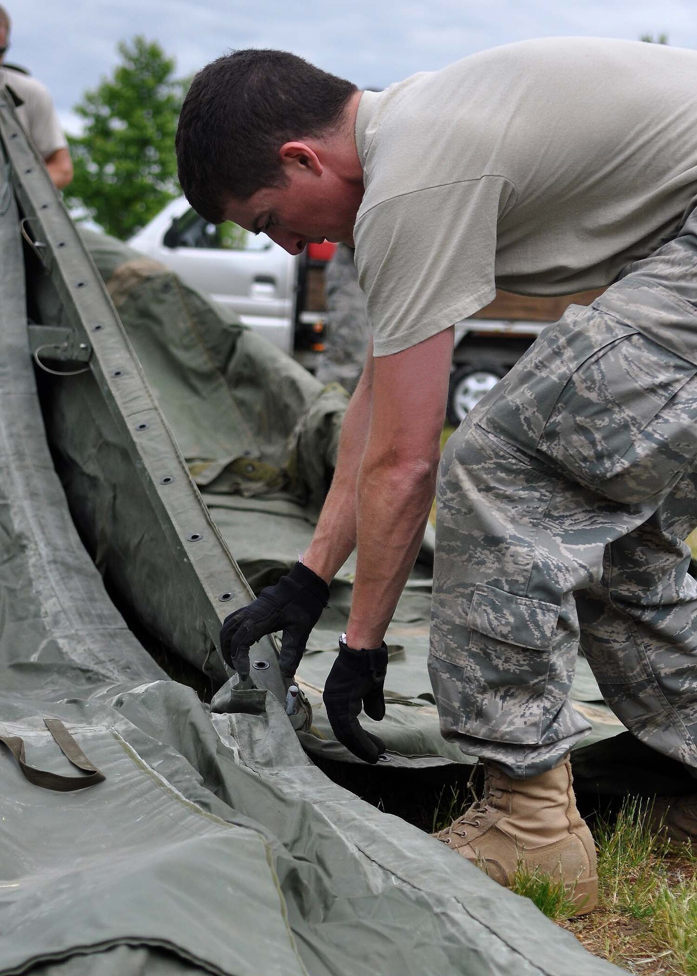 An Airman assigned to the 627th Civil Engineering Squadron helps set up tents at Heritage Hill June 21 at Joint Base Lewis-McChord, Wash. McChord Field’s Heritage Hill will be transformed into Rainier Ranch for the upcoming Air Mobility Command Rodeo. (U.S. Air Force photo illustration/Airman 1st Class Leah Young)