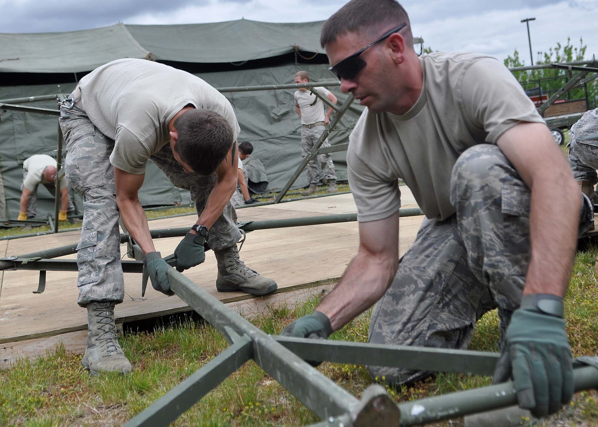 Two Airmen assigned to the 627th Civil Engineering Squadron set up tents at Heritage Hill June 21 at Joint Base Lewis-McChord, Wash. McChord Field’s Heritage Hill will be transformed into Rainier Ranch for the upcoming Air Mobility Command Rodeo. (U.S. Air Force photo/Airman 1st Class Leah Young)