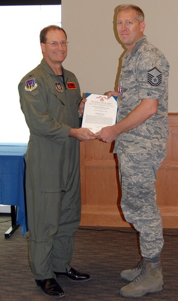NELLIS AIR FORCE BASE, Nev. -- (Right) Master Sgt. Brian Marr, 926th Force Support Squadron force management superintendent, receives a meritorious service medal from Col. Herman Brunke, Jr., 926th Group commander, during a commander's call here June 29. Sergeant Marr is departing the 926th FSS soon for the Air Force Personnel Center in Denver, Colo., to be the superintendent of force development. (U.S. Air Force photo/Capt. Jessica Martin)