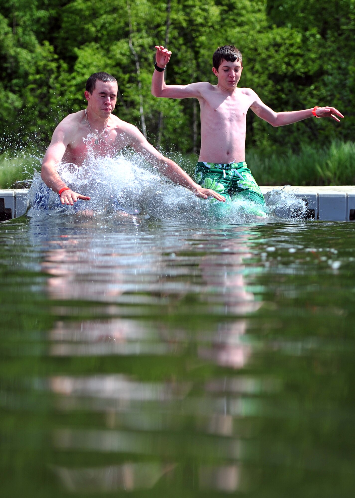 CAMP GORSUCH, Alaska???Airman 1st Class Tanner Volkers, left, a troop leader, and boy scout Gideon Wetherll, 14, both with JBER Troop 190, jump into the cold water at Camp Gorsuch Boy Scout camp where Boy Scout troops 109 and 504 from Joint Base Elmendorf-Richardson were camping for the week and performing tasks to earn scouting badges, Thursday, June 23, 2011.  (U.S. Air Force photo by Justin Connaher/JBER PA)