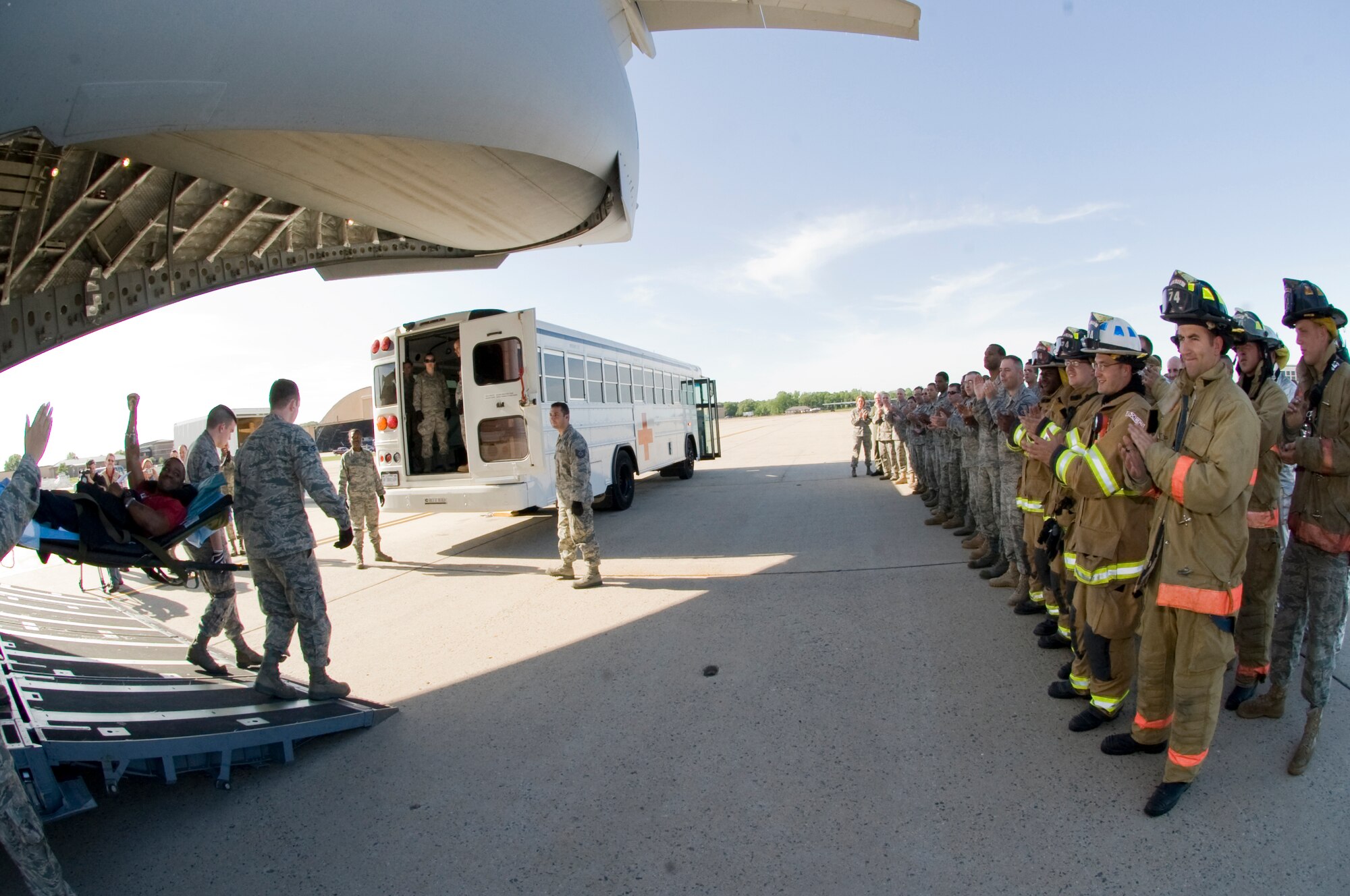 Tech. Sgt. John Knight, 2nd Civil Engineer Squadron firefighter, is carried off an aircraft while his fellow firefighters applaud him on the flightline at Andrews Air Force Base, Md., May 10. Sergeant Knight stopped at Andrews on his way back from Afghanistan, where he was wounded and presented with the Purple Heart. (Courtesy photo)