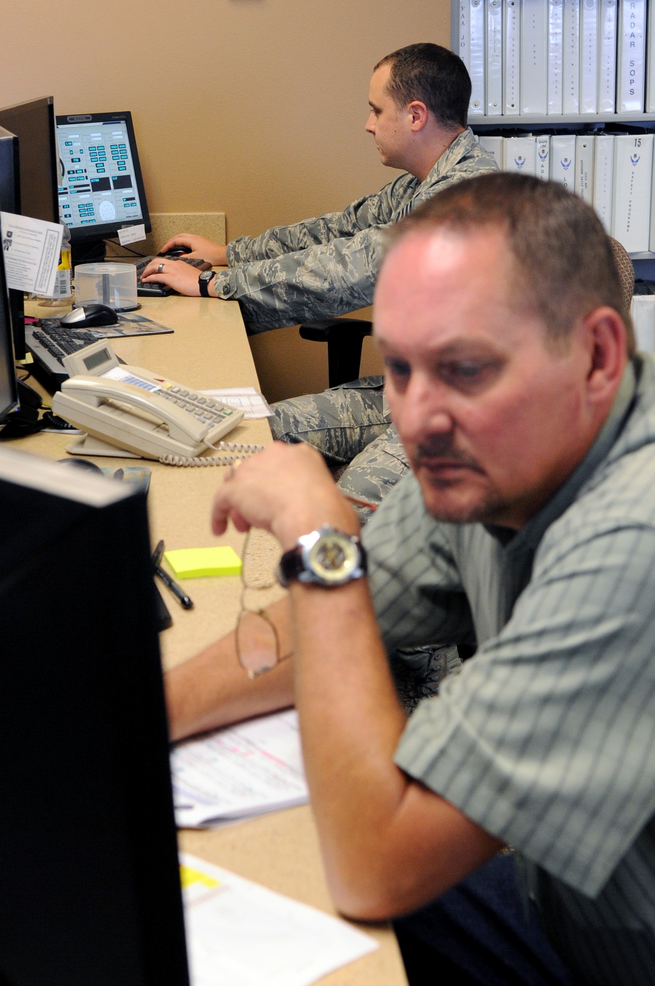 Mr. Lorne McClard, 2nd Operational Support Squadron meteorological technician and Staff Sgt. Larry Woodson, weather forecaster, monitors the radar for severe weather potential on Barksdale Air Force Base, La., June 30. This process is done continuously to help resource protection for Barksdale. (U.S. Air Force photo/Senior Airman La’Shanette V. Garrett)(RELEASED)