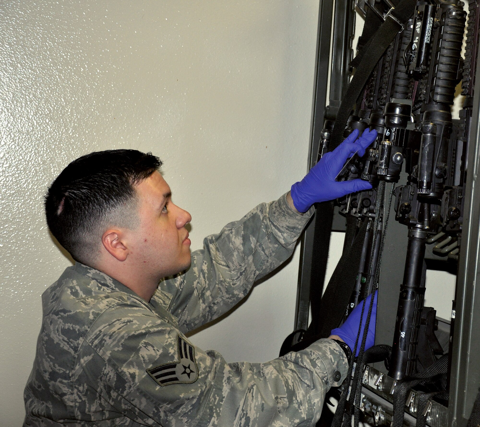 Senior Airman Jonathan Tavarez, 90th Security Support Squadron armory technician, stores an M4 Carbine during a recent exercise. As well as arming and disarming weapons and gear, armory technicians accomplish equipment inventories of issued gear five times per shift and a monthly serial number inventory. (U.S. Air Force photo by Staff Sgt. Mike Tryon)