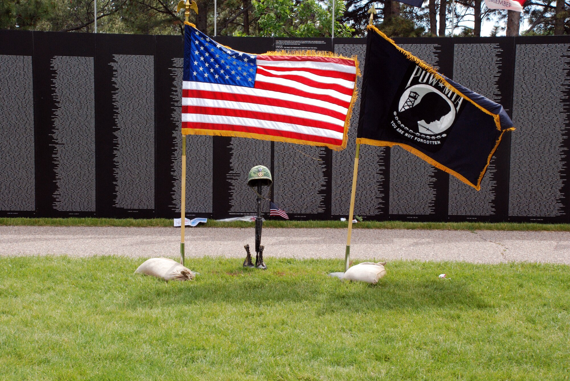 The American and Prisoner of War Flags stand in memorium to those who never returned from Vietnam during a traveling memorial at Lion's Park in Cheyenne, Wyo. June 24. The "Moving Wall" belongs to the Vietnam Combat Veterans and has been touring the country for more than 20 years. (U.S. Air Force photo by Staff Sgt. Torri Ingalsbe)