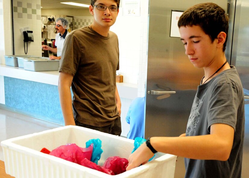 DYESS AIR FORCE BASE, Texas – Karl Nicholas, 17, son of Linda Nicholas, 7th Force Support Squadron, and Luke Schroeder, 11, son of Tech. Sgt. James Schroeder, 7th Mission Operations Squadron, pick up ready-made meals to deliver throughout the local Abilene community June 30, 2011. Children ages 9-18 from the youth center here perform a Meals-on-Wheels route every Thursday morning in the city of Abilene. (U.S. Air Force photo by Senior Airman Chelsea Browning/Released)