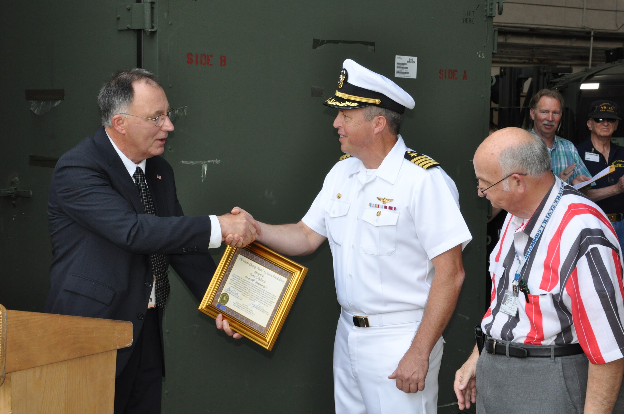 Gerry Little, Ocean County, N.J. Deputy Freeholder director, presents Capt. Andy Butterfield, 87th Air Base Wing, deputy commander, and Carl Jablonski, Navy Lakehurst Historical Society president, with a signed certificate celebrating the 90th anniversary of Hangar One on Lakehurst. Little recognized the contribution the servicemembers at Joint Base McGuire-Dix-Lakehurst make to the war on terror, and the impact the tri-service base has on the local community. (U.S. Air Force photo by Bill Addison/Released)