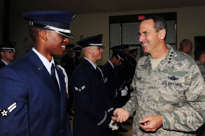 Gen. Raymond E. Johns Jr. coins Airman 1st Class Brandon Radcliff along with the entire Honor Guard team after a briefing June 29, which highlighted the Honor Guard mission and their recent ceremonies at Joint Base Charleston - Air Base, S.C.  General Johns is touring JB CHS - AB and Weapons Station durying a two-day base visit.  General Johns is the Air Mobility Command commander and Airman Radcliff is assigned to the 437th Aircraft Maintenance Squadron. (U.S. Air Force photo/Tech. Sgt. Chrissy Best) 