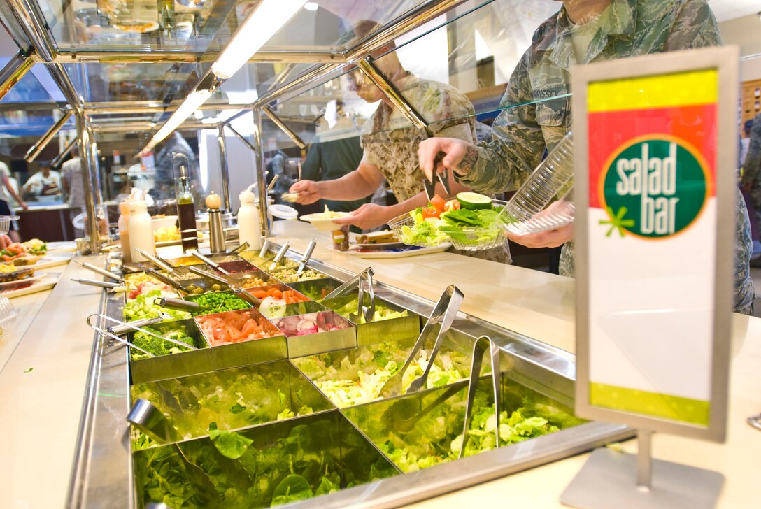 Team Little Rock members make their choices from the newly upgraded salad bar Oct. 6 inside the Hercules Dining Facility. The Food Transformation Initiative is a pilot program designed to provide Airmen with improved food quality, variety and availability, while maintaining home station and warfighting feeding capabilities. Pilot locations begin a campus style dining concept this summer. (U.S. Air Force photo by Staff Sgt. Nestor Cruz)