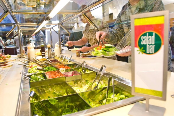 Team Little Rock members make their choices from the newly upgraded salad bar Oct. 6 inside the Hercules Dining Facility. The Food Transformation Initiative is a pilot program designed to provide Airmen with improved food quality, variety and availability, while maintaining home station and warfighting feeding capabilities. Pilot locations begin a campus style dining concept this summer. (U.S. Air Force photo by Staff Sgt. Nestor Cruz)