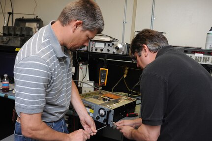 Larry Smith (left) and Joe Pranger, 902nd Communications Squadron airfield systems maintenance technicians, perform maintenance on a ground to air radio at Randolph Air Force Base June 23. Airfield systems maintenance technicians ensure all airfield systems operate to specifications. (U.S. Air Force photo/Rich McFadden) (released)
