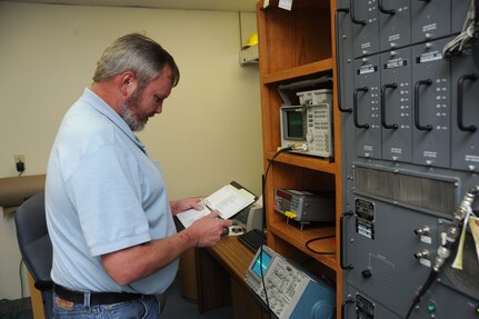 Dennis Bernsteen, 902nd Communications Squadron airfield systems maintenance technician, refers to the technical order while performing maintenance on the tactical air navigation system on Randolph Air Force Base June 23.  Airfield systems maintenance technicians ensure
 all airfield systems operate to specifications. (U.S. Air Force photo/Rich McFadden) (released)